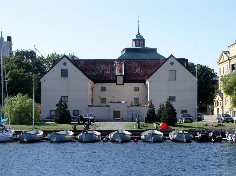 Örlogshamnen i Karlskrona med en fortifierad byggnad och hamn för båtar framför.